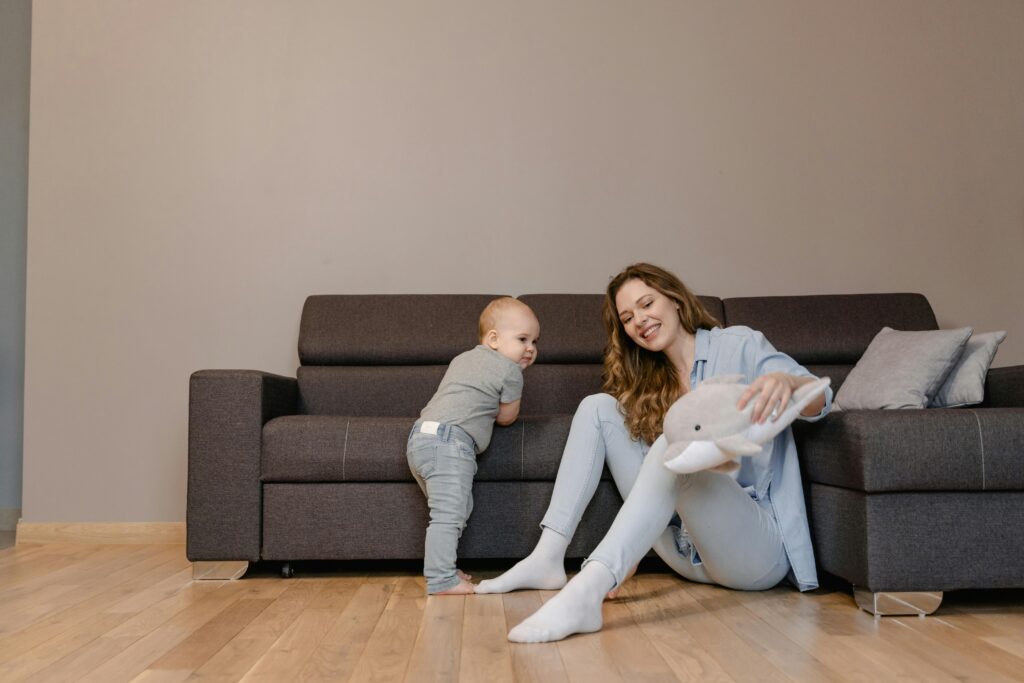 A joyful mother and her baby playing together on the living room floor, creating tender family moments.